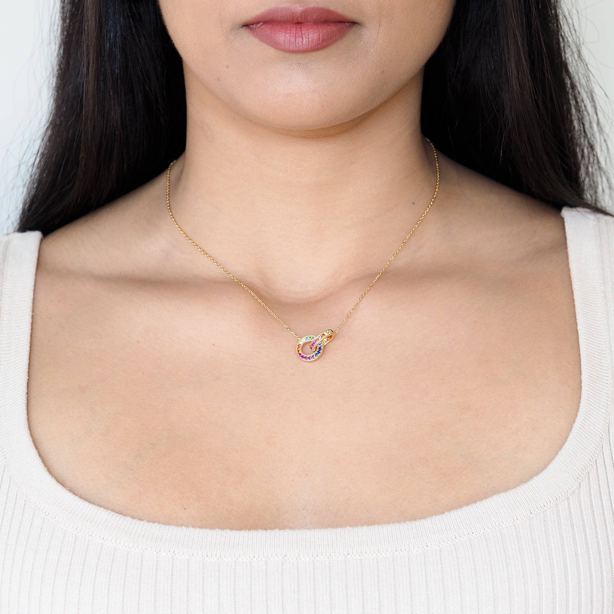 Rainbow Necklace featuring double ring elements and the colours of the rainbow LGBT pride flag, model