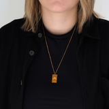 pride tag necklace with rainbow symbol and pride text in pride jewellery collection, model gold