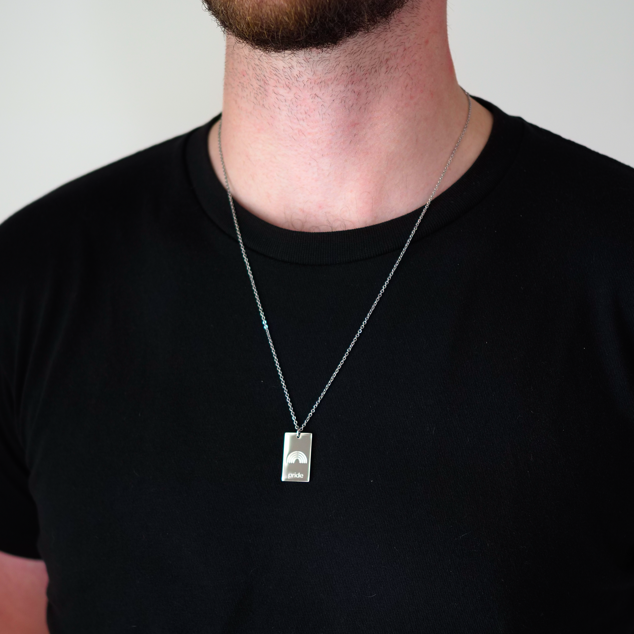 pride tag necklace with rainbow symbol and pride text in pride jewellery collection, model 1